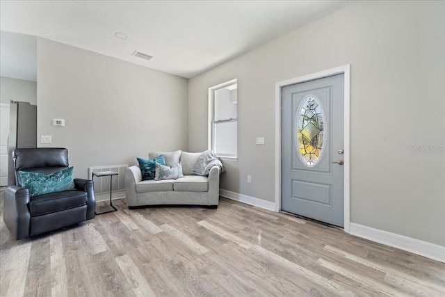 interior space featuring baseboards, visible vents, and light wood finished floors