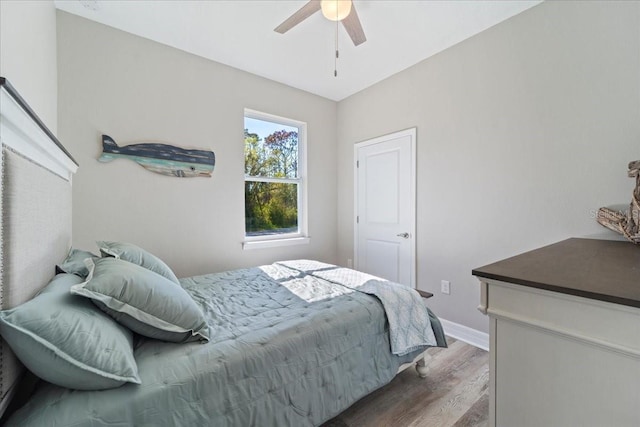 bedroom featuring ceiling fan, wood finished floors, and baseboards