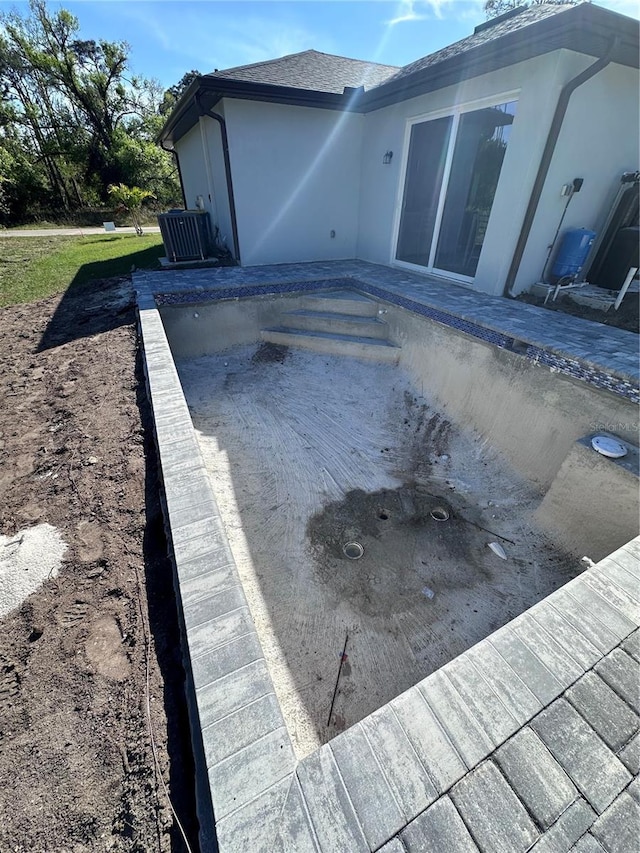 view of swimming pool with central air condition unit