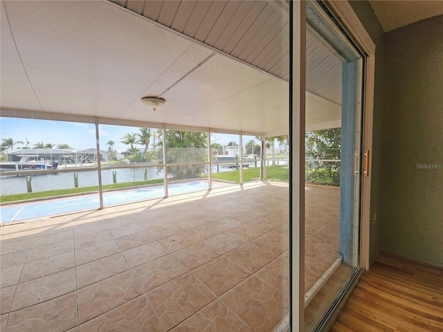 unfurnished sunroom featuring a water view