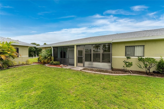 back of property with a yard and a sunroom