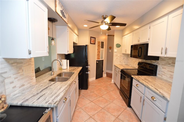 kitchen featuring white cabinetry, sink, light tile patterned flooring, and black appliances