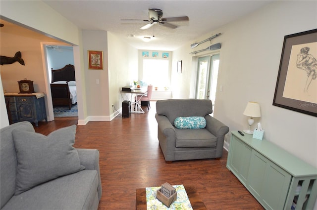 living room featuring ceiling fan and dark hardwood / wood-style floors