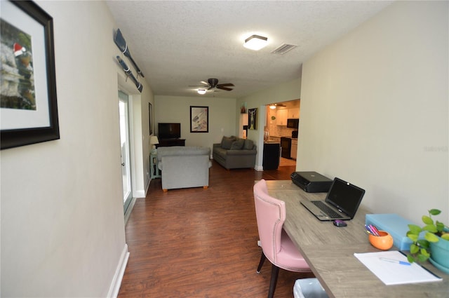 home office with ceiling fan, dark hardwood / wood-style floors, and a textured ceiling