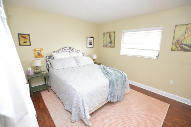 bedroom with dark hardwood / wood-style floors