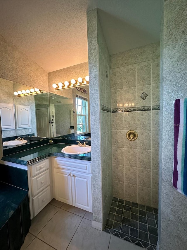 bathroom featuring vanity, a tile shower, and tile patterned floors