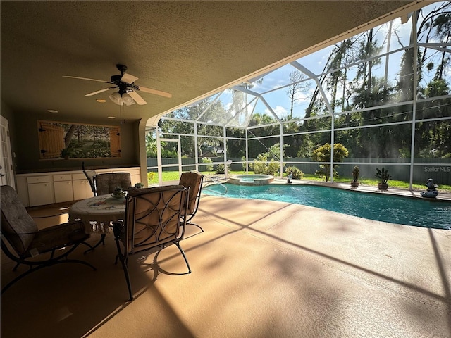 view of swimming pool featuring a patio area, an in ground hot tub, a lanai, and ceiling fan