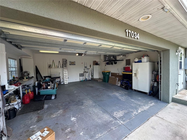 garage featuring white fridge with ice dispenser