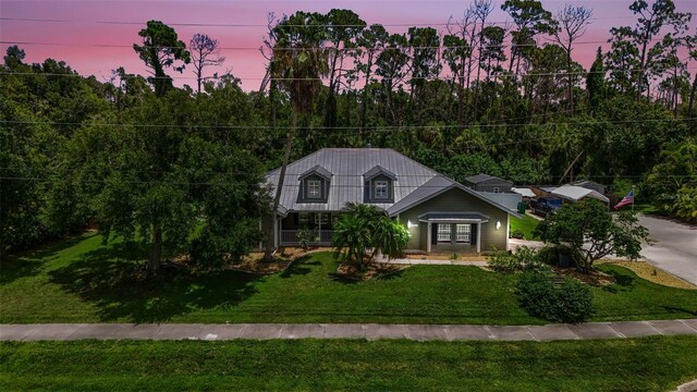 cape cod-style house featuring a lawn