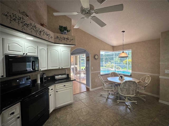 kitchen with white cabinetry, lofted ceiling, black appliances, and pendant lighting