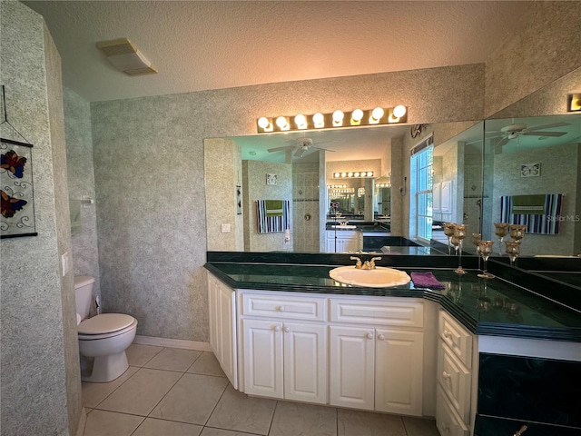 bathroom with vanity, tile patterned floors, ceiling fan, toilet, and a textured ceiling