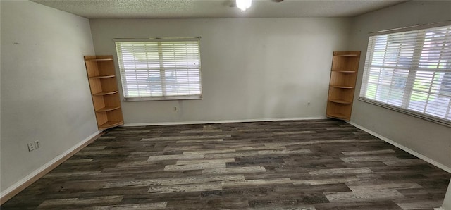 unfurnished room with a textured ceiling and dark wood-type flooring