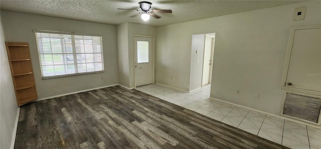 tiled entryway featuring a textured ceiling and ceiling fan