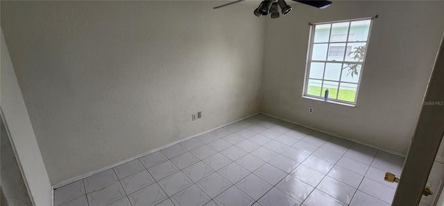 tiled spare room featuring ceiling fan and a healthy amount of sunlight