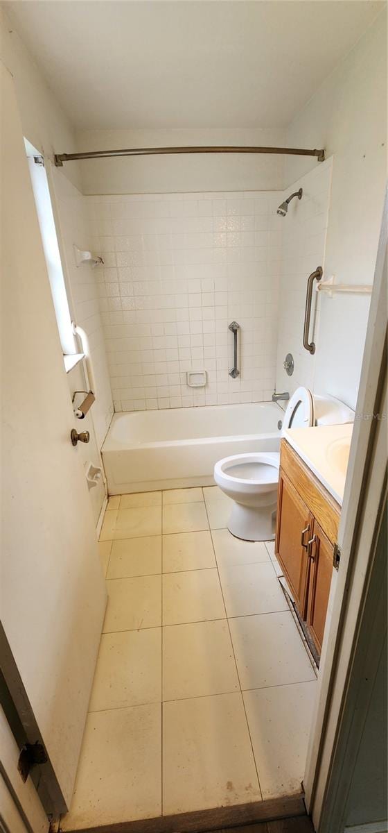 full bathroom featuring toilet, tile patterned flooring, tiled shower / bath, and vanity