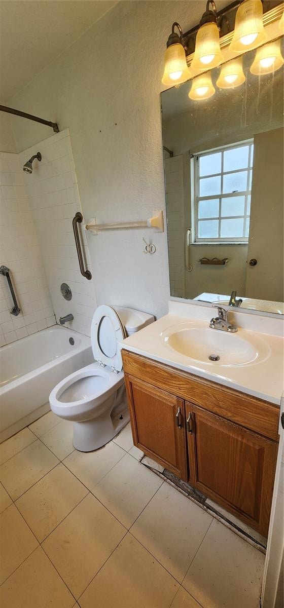 full bathroom featuring tile patterned floors, toilet, vanity, and tiled shower / bath