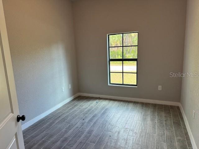 unfurnished room featuring dark wood-type flooring