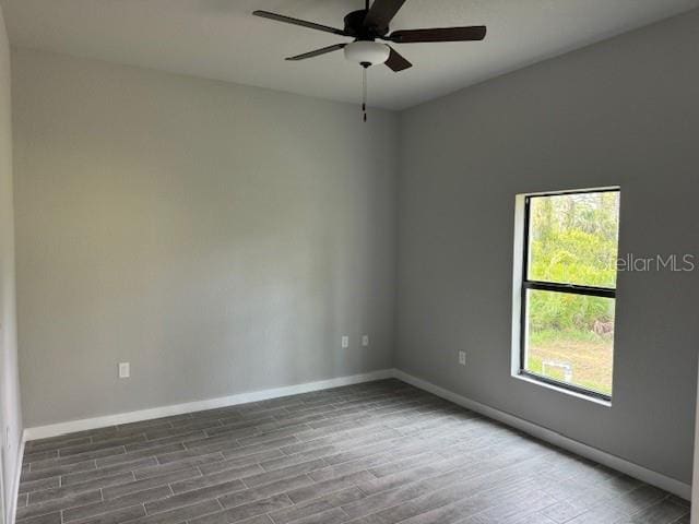 empty room featuring ceiling fan, a wealth of natural light, and hardwood / wood-style floors