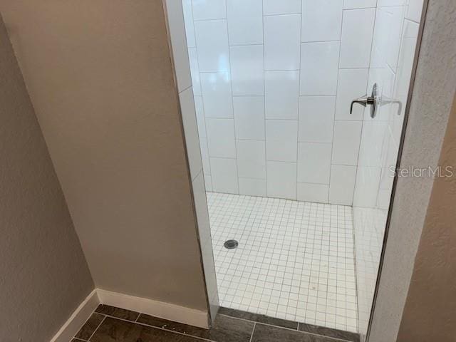 bathroom featuring a tile shower and tile patterned flooring