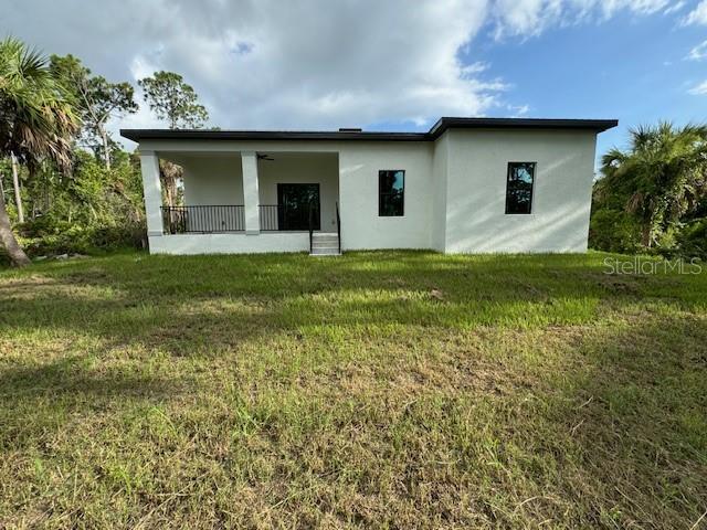 rear view of house featuring a lawn