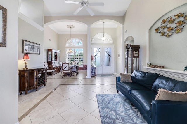 tiled living room featuring ornamental molding, ceiling fan, and french doors