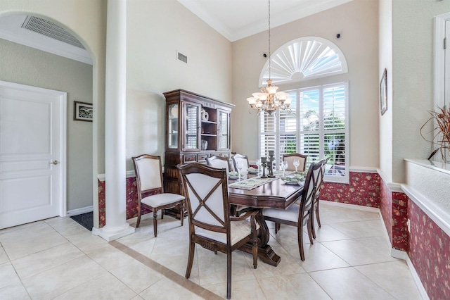 dining space featuring crown molding, a towering ceiling, light tile patterned floors, and a notable chandelier