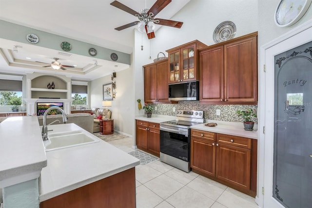 kitchen with electric stove, a raised ceiling, sink, and decorative backsplash