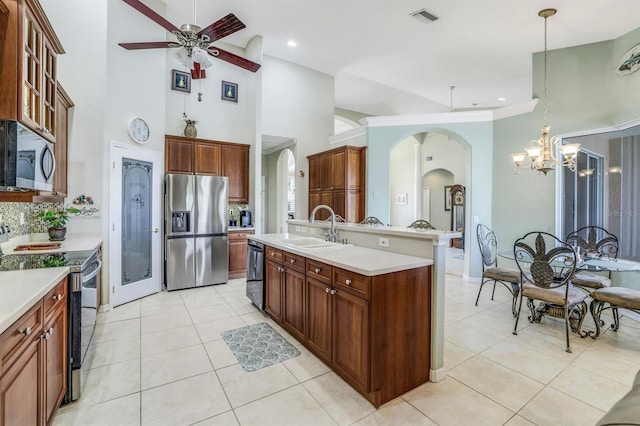 kitchen featuring pendant lighting, sink, a high ceiling, a kitchen island with sink, and stainless steel appliances