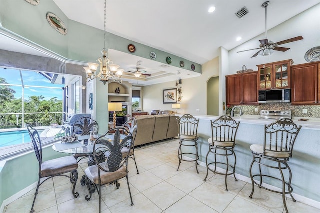 kitchen featuring a breakfast bar, stainless steel appliances, decorative backsplash, decorative light fixtures, and kitchen peninsula