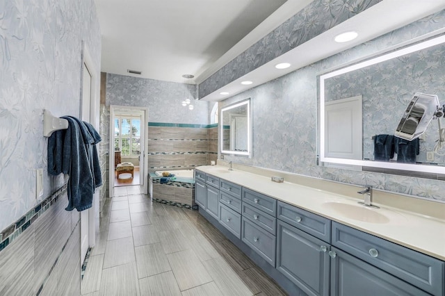 bathroom featuring vanity and tiled bath