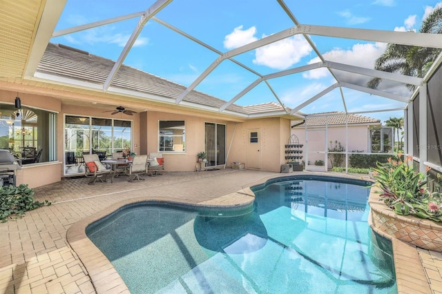 view of pool featuring a patio area, ceiling fan, and glass enclosure