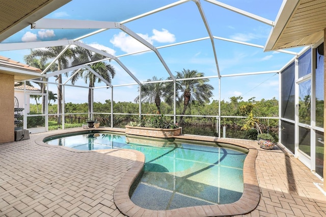 view of swimming pool featuring a lanai and a patio area