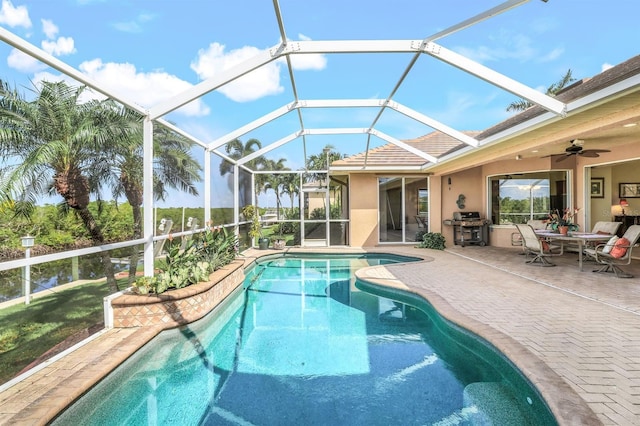 view of pool featuring a patio area, ceiling fan, and glass enclosure