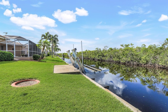 dock area with a water view, a yard, and glass enclosure