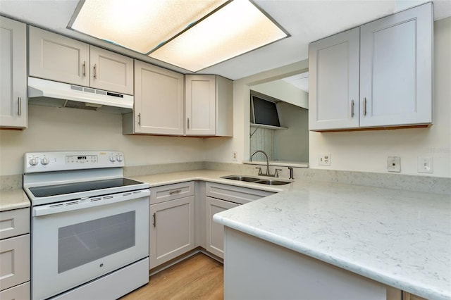 kitchen with gray cabinets, white electric range, a sink, and under cabinet range hood