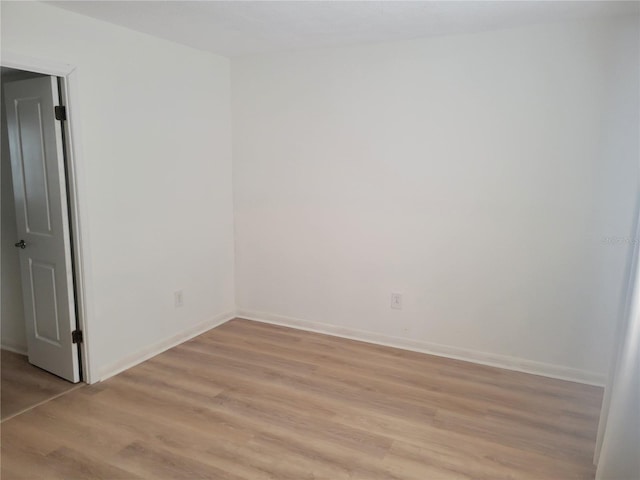 unfurnished room with light wood-style flooring and baseboards