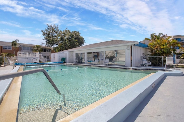 pool with a patio and fence