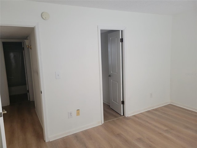 empty room with baseboards and wood finished floors