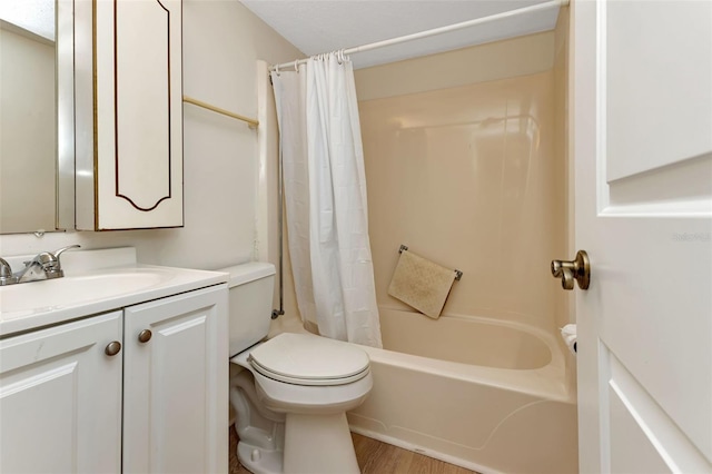 bathroom with toilet, shower / bath combo with shower curtain, wood finished floors, and vanity