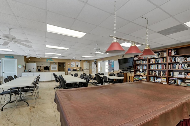 interior space featuring a paneled ceiling and ceiling fan