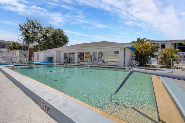 community pool with fence and a patio