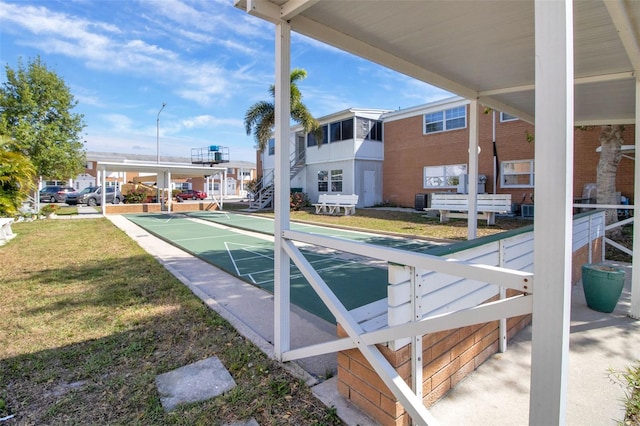 view of community with a yard and shuffleboard