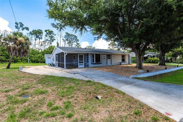 ranch-style home with a front lawn and a sunroom