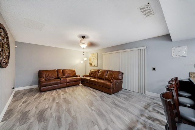 living room featuring ceiling fan and light hardwood / wood-style floors