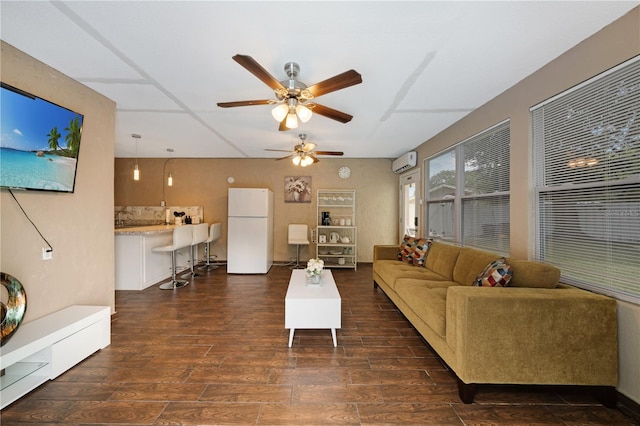 living room with a wall mounted AC, dark hardwood / wood-style flooring, and ceiling fan