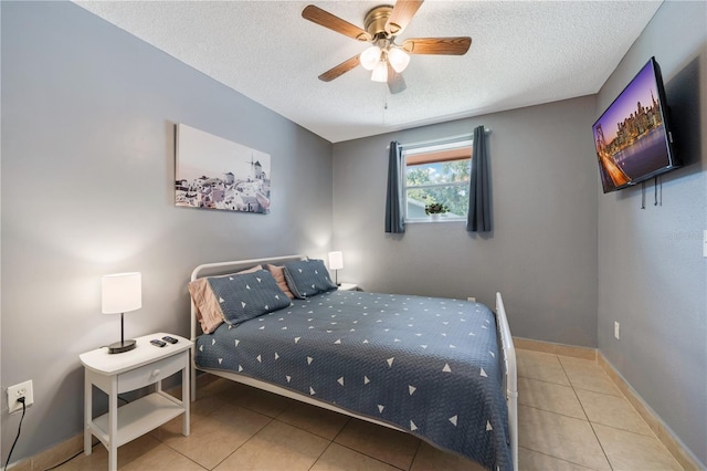 bedroom featuring a textured ceiling, ceiling fan, and tile patterned flooring