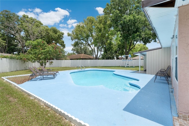 view of swimming pool featuring a lawn and a patio area