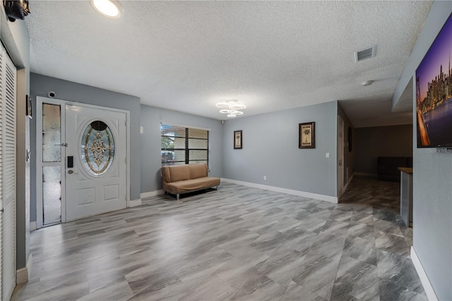 foyer entrance with a textured ceiling and hardwood / wood-style floors