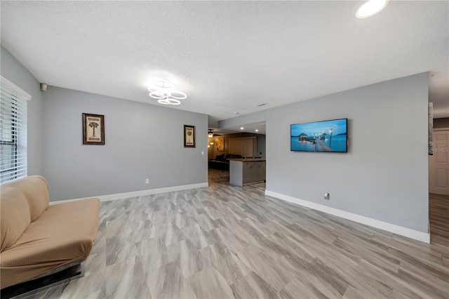 living room with a textured ceiling and light hardwood / wood-style flooring