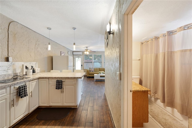 kitchen with black electric stovetop, white cabinets, white refrigerator, dark hardwood / wood-style flooring, and ceiling fan